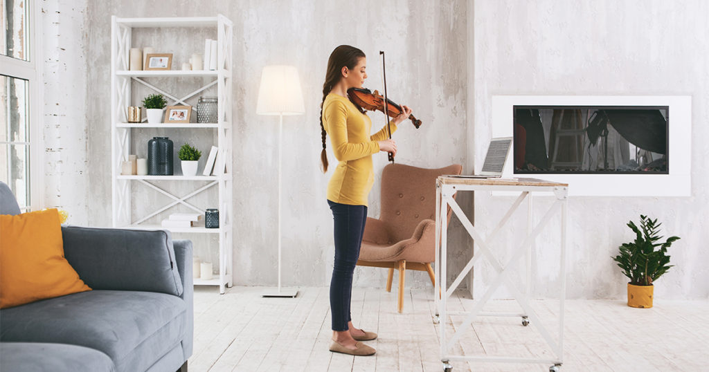 woman playing the violin at home